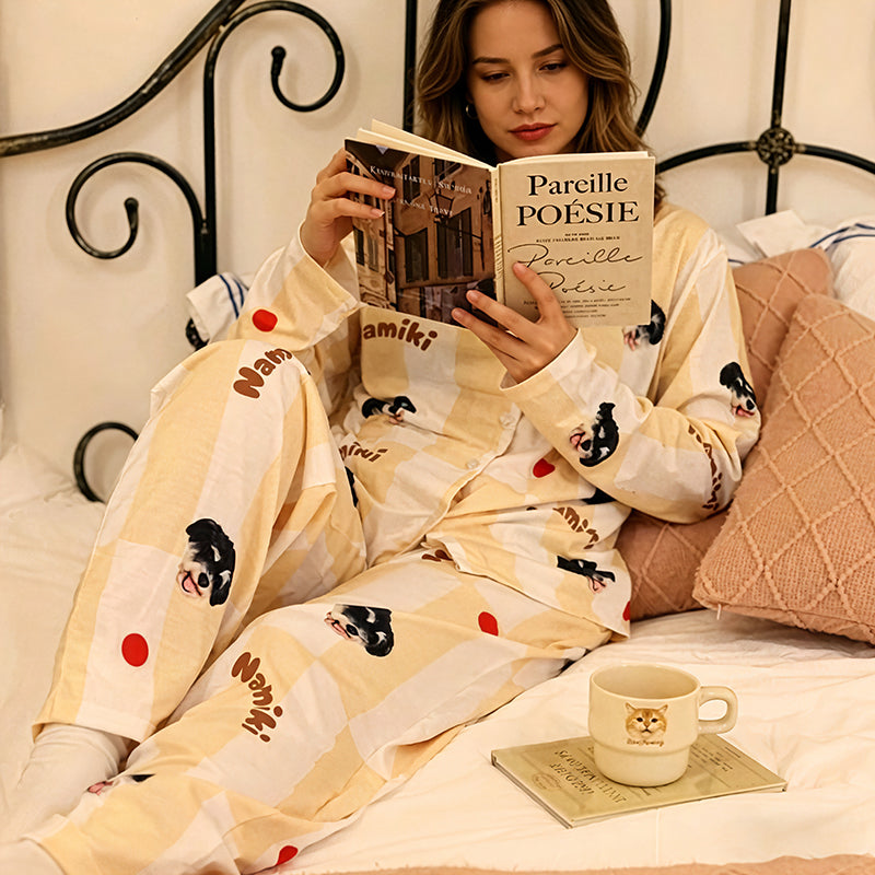 Woman wearing custom dog face pajama in light yellow stripes, sitting on bed reading a book