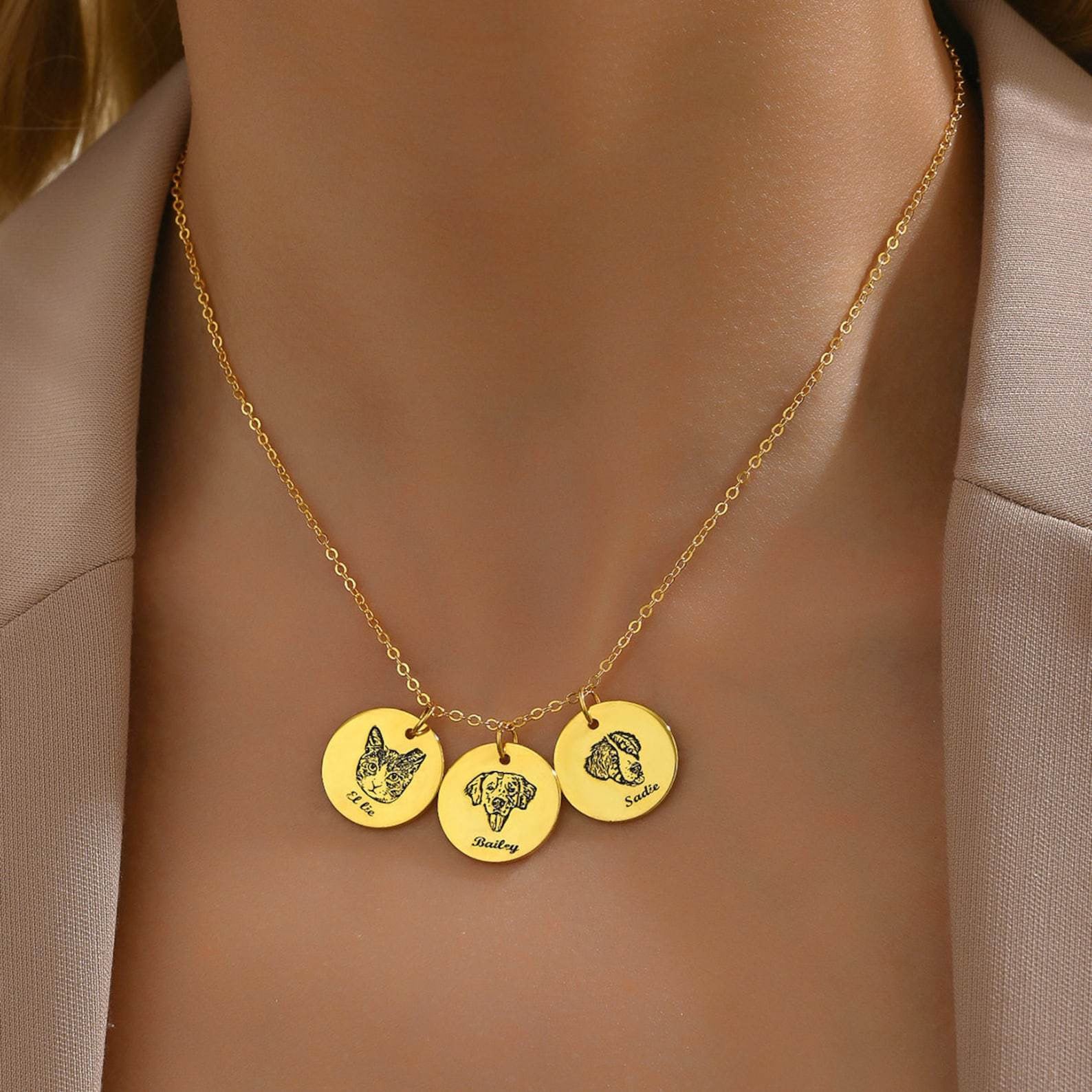 Close-up of gold personalized pet memorial necklace with engraved cat and dog pendants