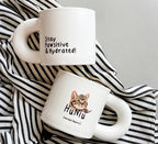 White ceramic cat mug with motivational quote "Stay Pawsitive & Hydrated", perfect for dog lovers