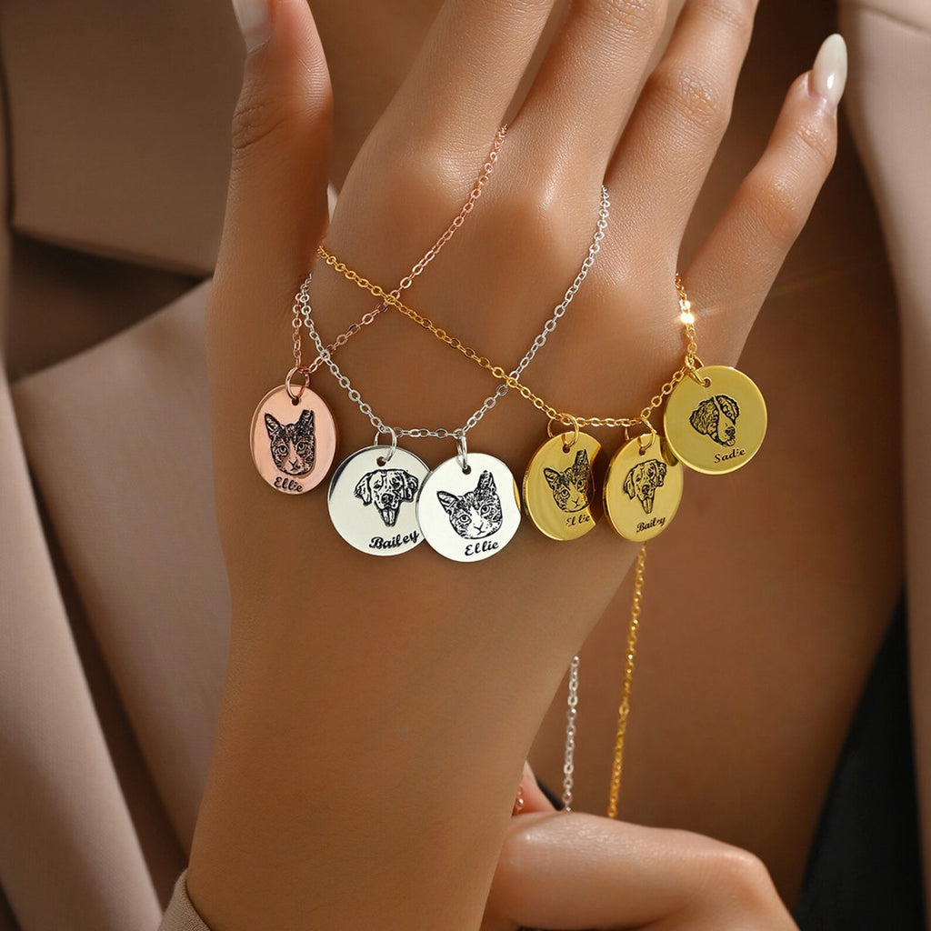 Personalized pet memorial necklace with engraved cat and dog pendants worn on hand