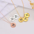 Flat lay of personalized pet memorial necklaces in gold, silver, and rose gold with cat and dog engravings