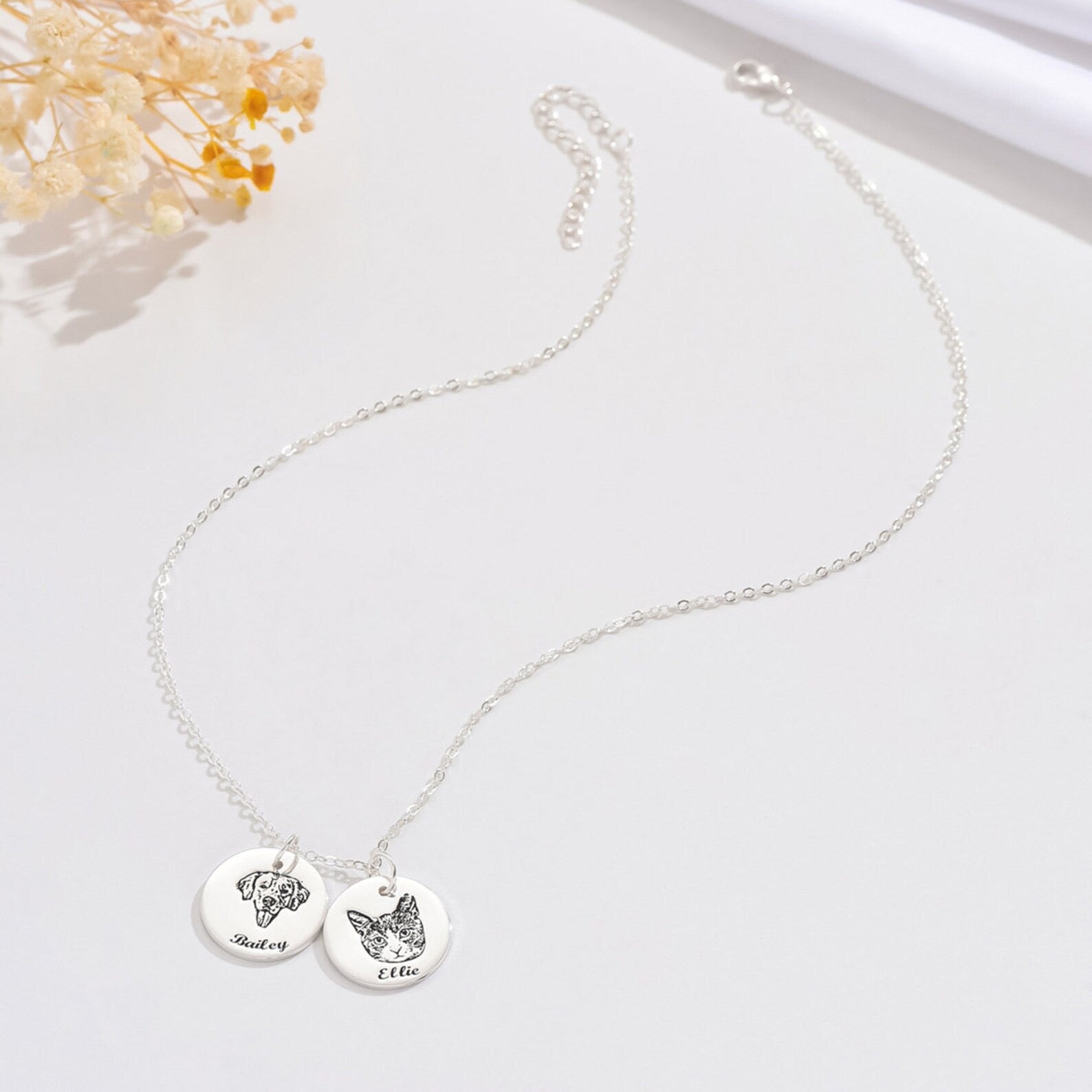 Silver personalized pet memorial necklace with engraved cat and dog charms on white background